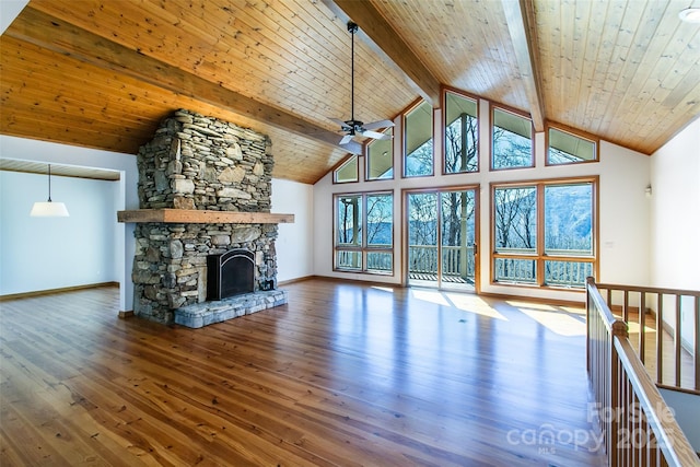 unfurnished living room featuring a ceiling fan, beamed ceiling, a fireplace, high vaulted ceiling, and wood finished floors