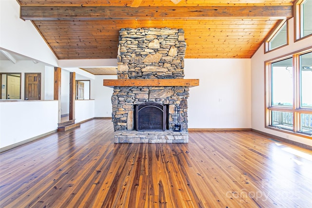 unfurnished living room featuring wood finished floors, baseboards, beamed ceiling, and a fireplace