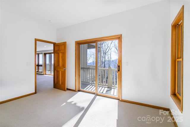 spare room with light carpet and baseboards