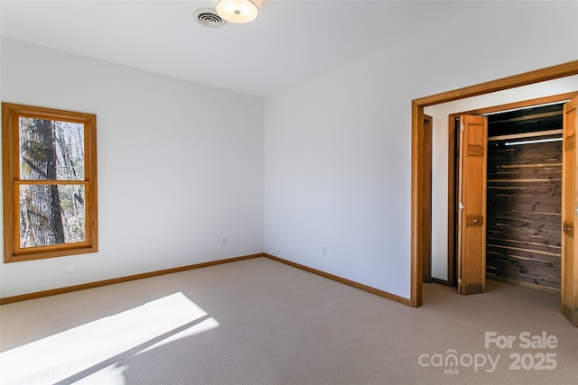 unfurnished bedroom featuring carpet floors, a closet, baseboards, and visible vents