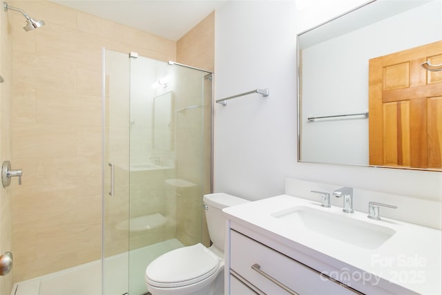 full bathroom featuring toilet, a stall shower, and vanity