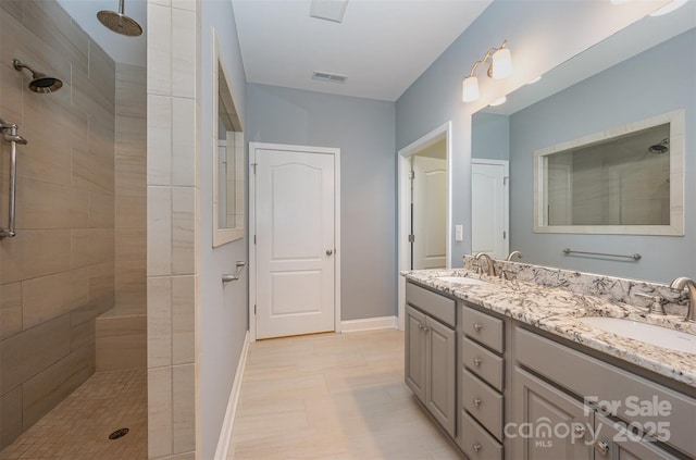 bathroom featuring vanity and tiled shower