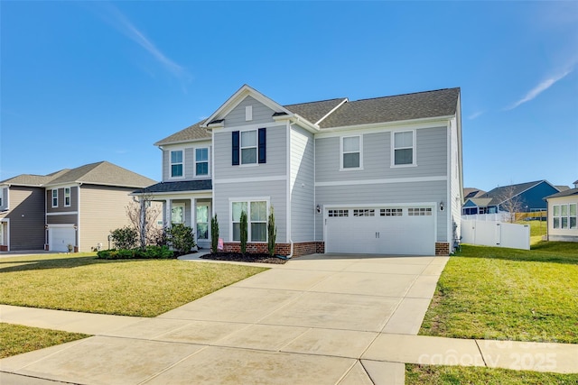 traditional-style home featuring a garage, fence, concrete driveway, and a front yard