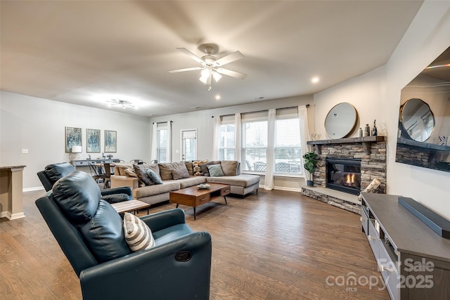 living room featuring ceiling fan, recessed lighting, a fireplace, wood finished floors, and baseboards