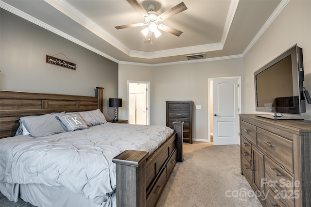 bedroom with light colored carpet, a ceiling fan, visible vents, ornamental molding, and a tray ceiling