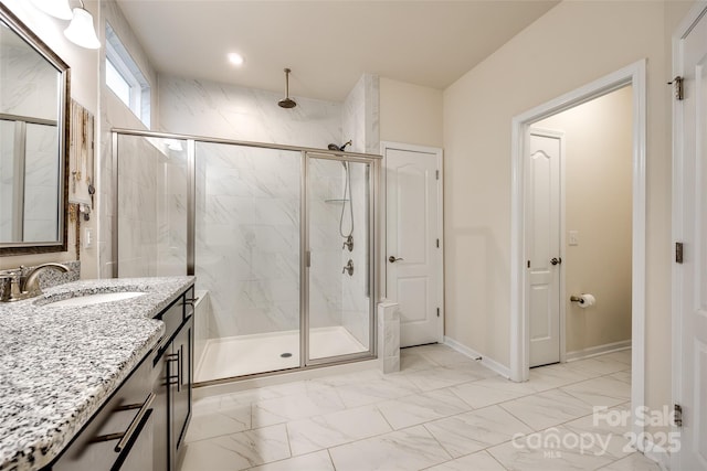 full bathroom featuring a stall shower, marble finish floor, vanity, and baseboards