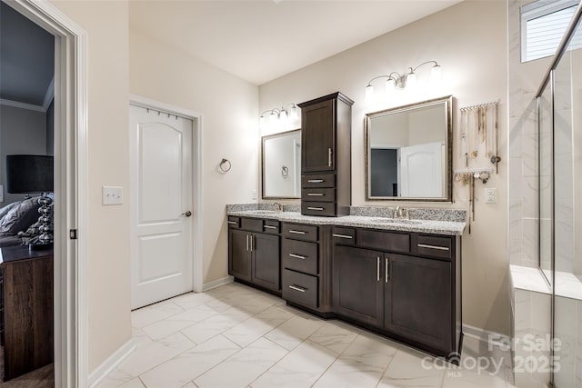 bathroom featuring marble finish floor, a sink, baseboards, and double vanity