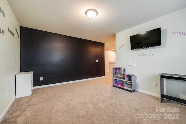 interior space with light carpet, an accent wall, visible vents, and baseboards