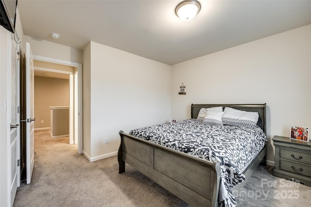 bedroom with light carpet and baseboards