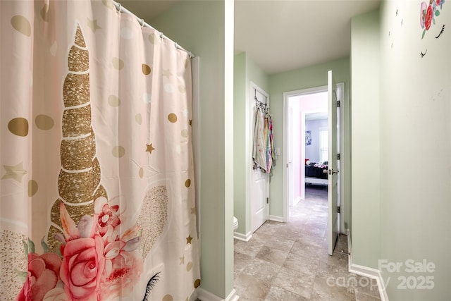 bathroom featuring toilet and baseboards