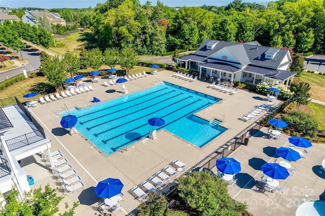 community pool with a patio and fence