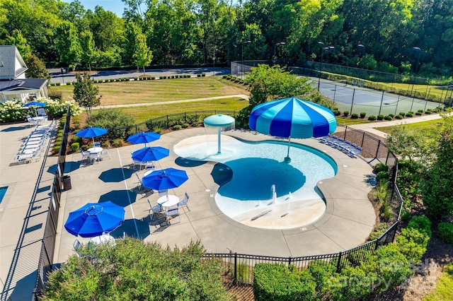 pool with a lawn, a water play area, and fence