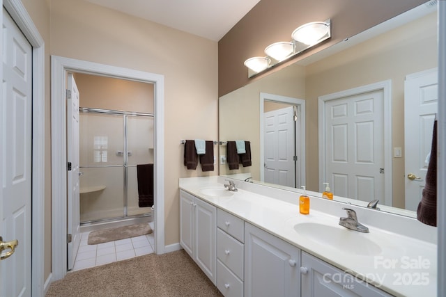 bathroom with tile patterned floors, a shower with shower door, and vanity