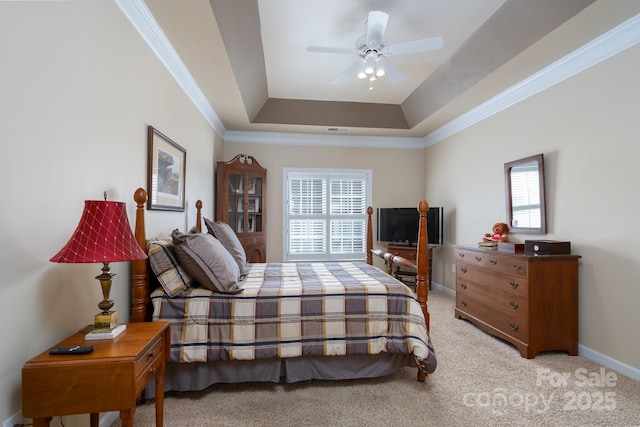 carpeted bedroom with crown molding and a raised ceiling