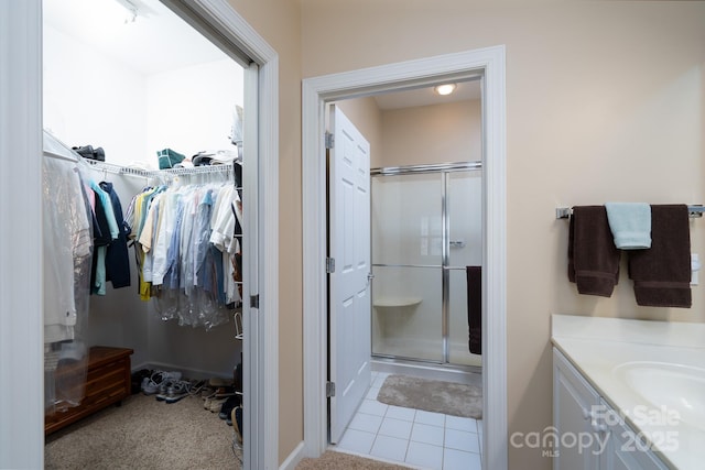 bathroom featuring vanity, a shower with door, and tile patterned floors