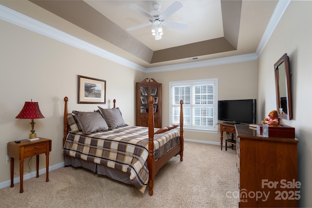 carpeted bedroom featuring a tray ceiling, crown molding, and ceiling fan