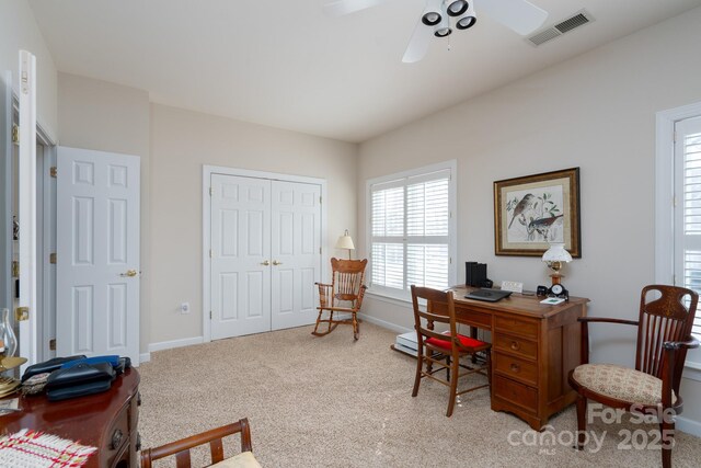 carpeted office space featuring ceiling fan