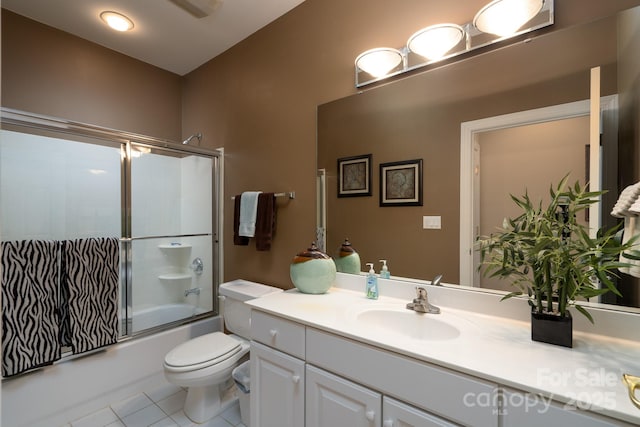 full bathroom with toilet, vanity, tile patterned flooring, and enclosed tub / shower combo