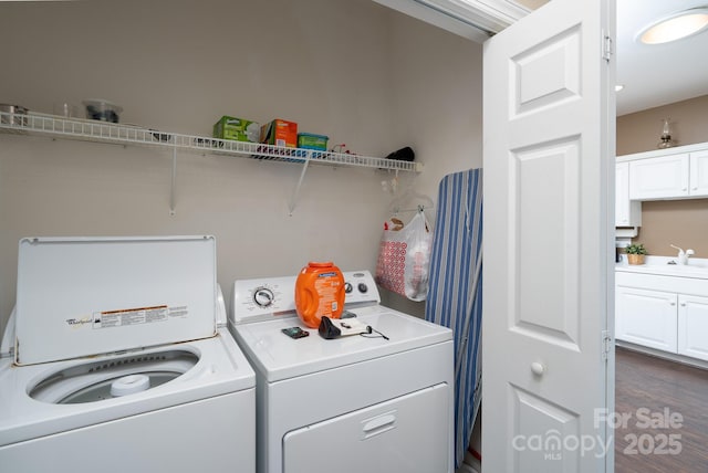 washroom with sink, dark wood-type flooring, and washing machine and clothes dryer