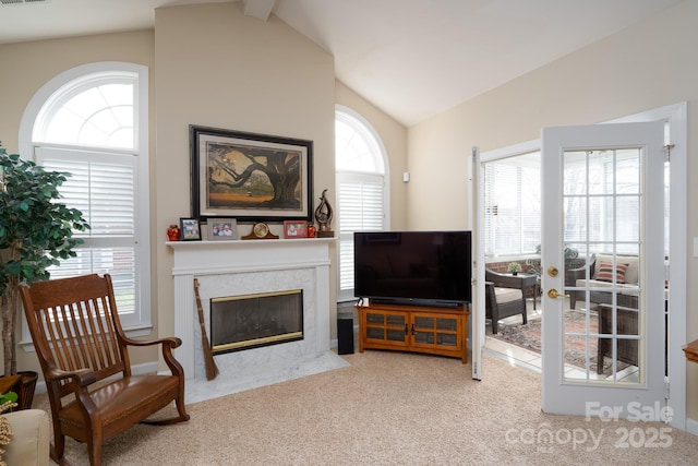 living room featuring vaulted ceiling, french doors, light carpet, and a high end fireplace