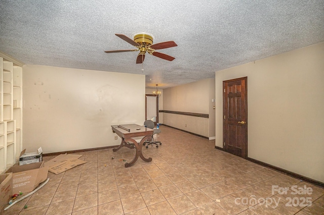 tiled spare room with ceiling fan with notable chandelier and a textured ceiling