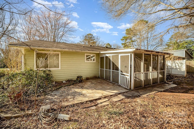 rear view of property with a patio and a sunroom