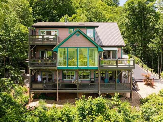 back of house featuring a sunroom and metal roof