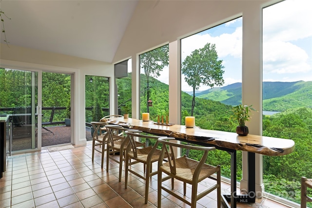 sunroom with lofted ceiling and a mountain view