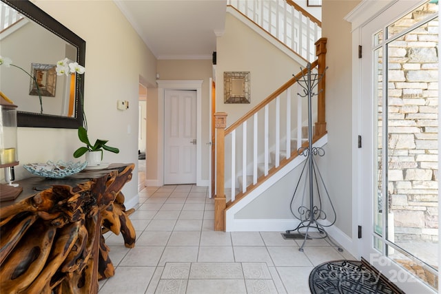 foyer entrance with light tile patterned floors, stairway, baseboards, and crown molding