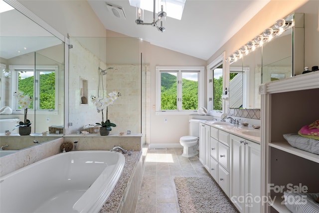 full bathroom featuring toilet, lofted ceiling with skylight, a garden tub, and a wealth of natural light