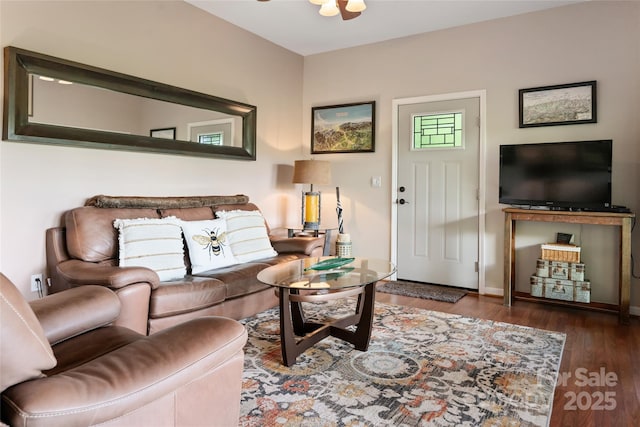 living area with a ceiling fan and dark wood-style flooring