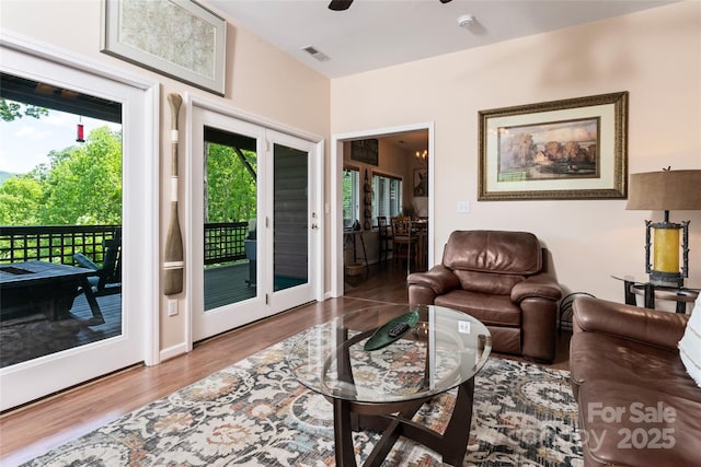 living area with wood finished floors, visible vents, and a ceiling fan