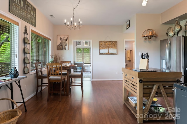 dining space featuring baseboards, dark wood finished floors, visible vents, and a notable chandelier