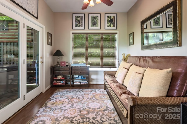 living area featuring dark wood finished floors, baseboards, and ceiling fan