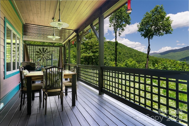 deck with a ceiling fan and a mountain view