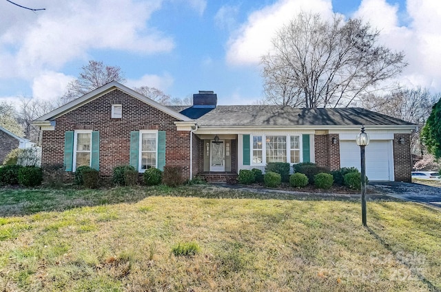 single story home featuring an attached garage, a chimney, a front lawn, aphalt driveway, and brick siding