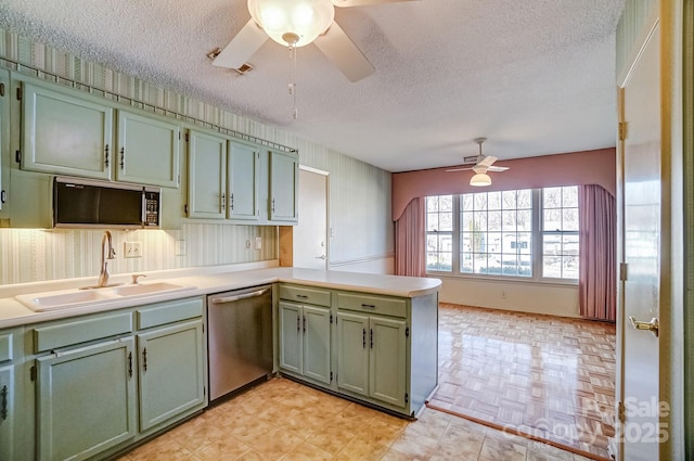 kitchen featuring green cabinetry, stainless steel dishwasher, a ceiling fan, and a sink