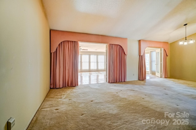 spare room featuring carpet flooring and arched walkways