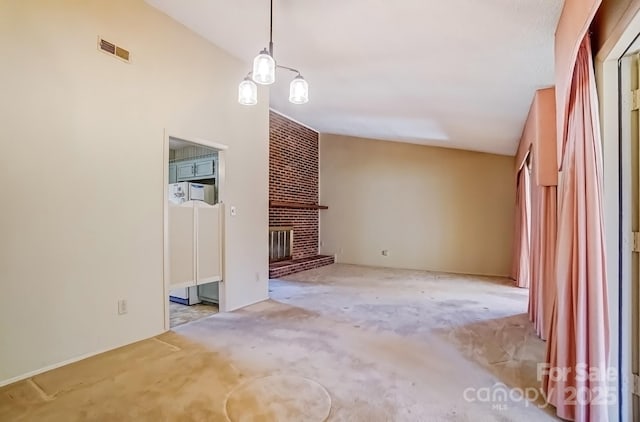 unfurnished living room with visible vents, a fireplace, and lofted ceiling