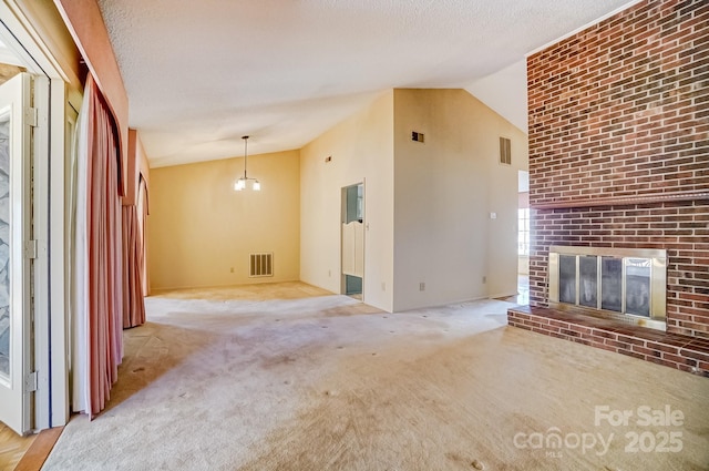 unfurnished living room featuring visible vents, high vaulted ceiling, a brick fireplace, and carpet flooring