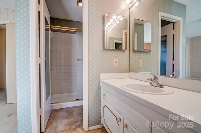 full bath with a shower stall, wallpapered walls, and vanity