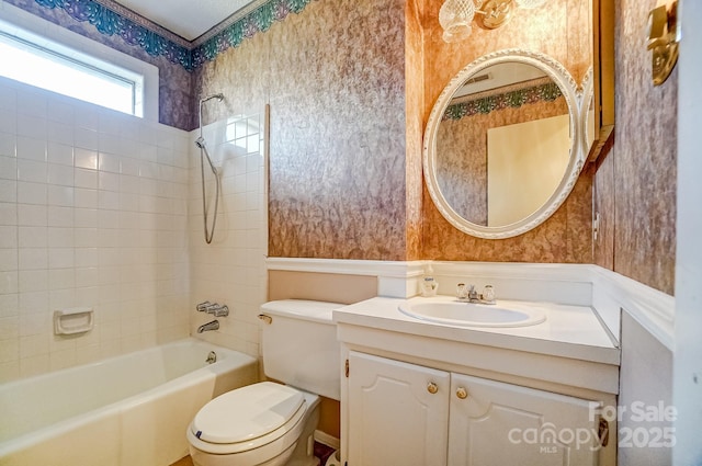 bathroom featuring wallpapered walls, vanity, toilet, and bathtub / shower combination