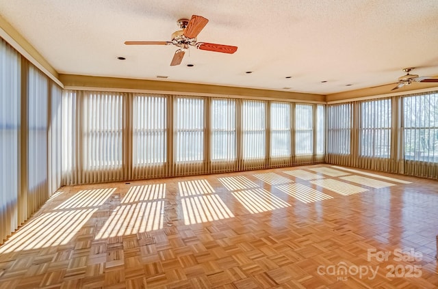 unfurnished sunroom featuring a ceiling fan