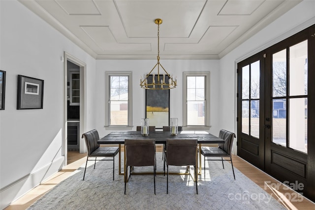 dining room featuring french doors, a chandelier, and light hardwood / wood-style floors