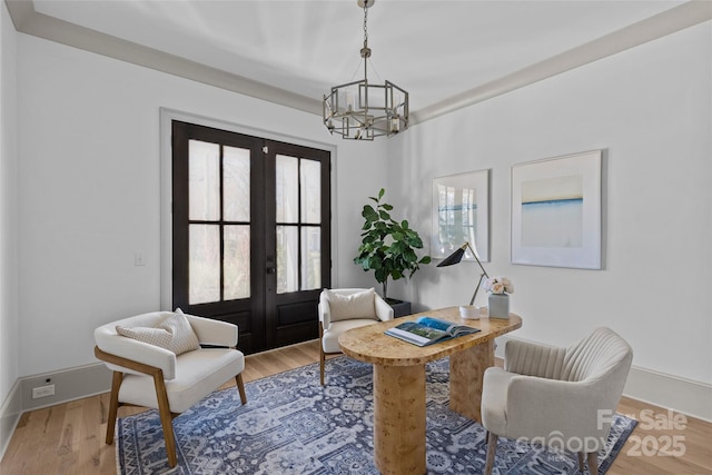 sitting room featuring hardwood / wood-style floors, a chandelier, and french doors