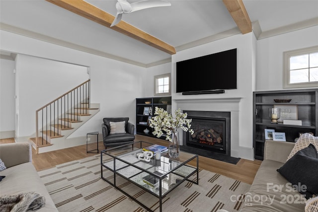 living room with a wealth of natural light, beamed ceiling, and light hardwood / wood-style floors