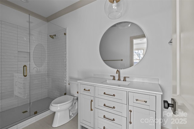 bathroom with toilet, vanity, and a shower with shower door