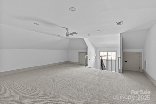 additional living space featuring ceiling fan, lofted ceiling, and light carpet