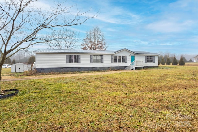 view of front of home with a front yard and a storage shed