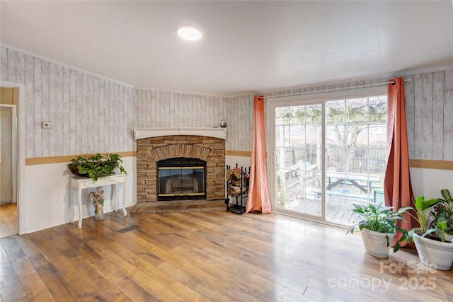 living room with wood-type flooring and a stone fireplace